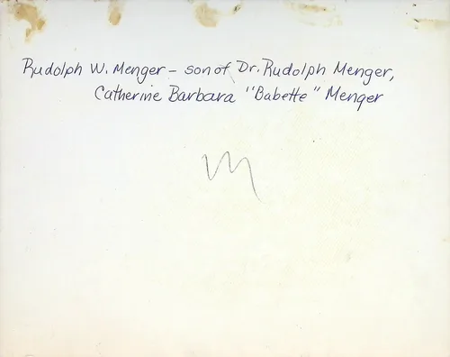 Rudolph W. Menger (identification) — Handwritten verso reading: "Rudolph W. Menger - son of Dr. Rudolph Menger, Catherine Barbara \"Babette\" Menger". A small scribbled "M" appears in the center. The page is otherwise blank with some staining at the top.