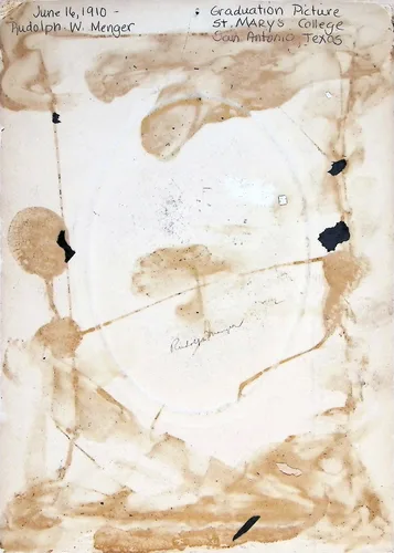 Rudolph W. Menger graduation (verso) — 1910 — Heavily water-stained verso of a photograph with handwriting: "June 16, 1910 - Rudolph W. Menger" and "Graduation Picture St. Mary's College San Antonio, Texas". A faint signature "Rudolph Menger[?]" appears in the center.