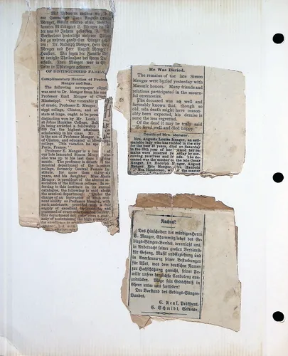 Menger newspaper clippings (German/English) — Scrapbook page with several torn newspaper clippings, some in German. One English clipping headed "He Was Buried." reads "The remains of the late Simon Menger were buried yesterday with Masonic honors..." Another, "Complimentary Mention of Professor Menger and Son", discusses Professor Emil Menger. A German clipping headed "Nachruf!" is signed "E. Kral, Präsident. C. Schmidt, Sekretär."