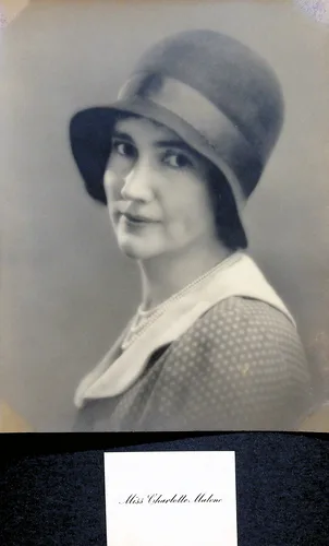 Miss Charlotte Malone portrait — Studio portrait of a young woman wearing a cloche hat and a polka-dot dress with a wide collar. A printed card below reads "Miss Charlotte Malone".
