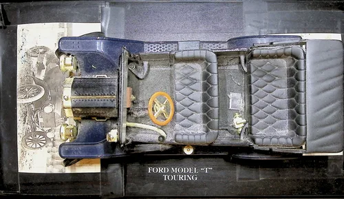 Ford Model T Touring (overhead) — Color photo of a dark blue model car shown from above, captioned "FORD MODEL \"T\" TOURING". An old black-and-white photo of a car or carriage is tucked beneath it at the left edge.